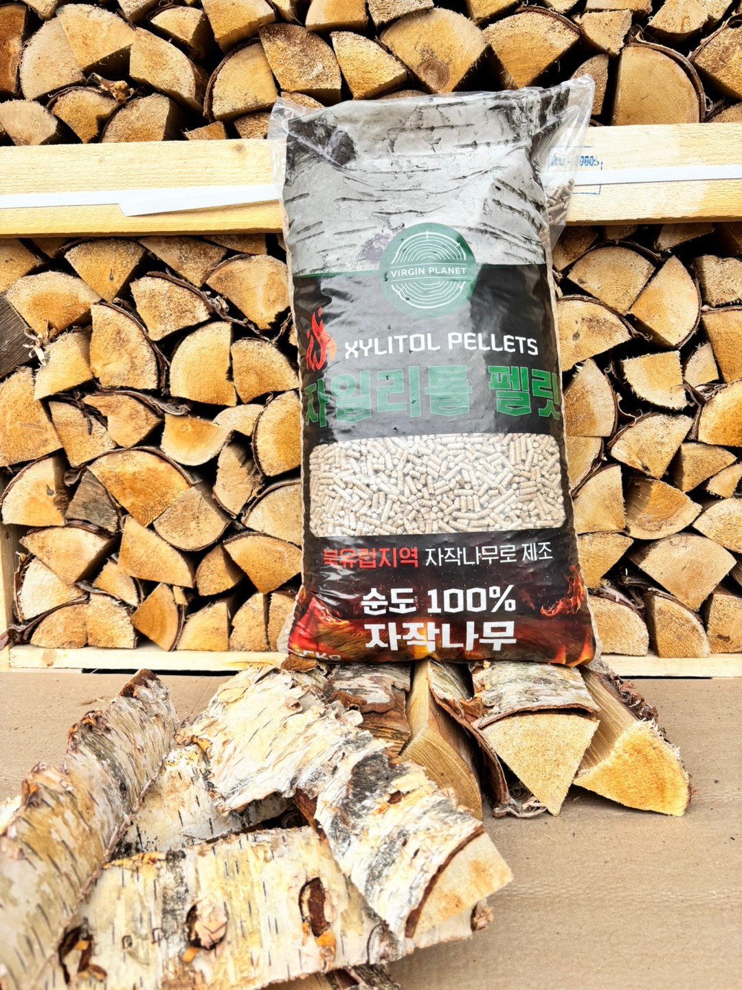 Past Virgin Planet Xylitol pellet bag photographed against stacked firewood